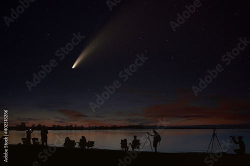 Comet Neowise comet C 2020 F3  NEOWISE  and crowd of people  silhouetted by the Ottawa river watching and photographing the comet