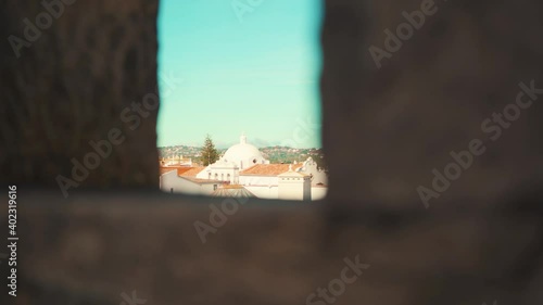 Portugal Loule city revealed by castle wall battlements under blue sky with truck camera movement 4K photo