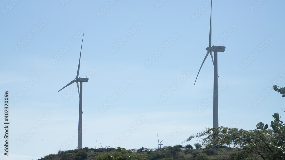 WIND GENERATORS IN A CLEAN ENERGY PARK ON TOP OF A HILL WITH THE SKY IN THE BACKGROUND WIND GENERATORS IN A CLEAN ENERGY PARK ON TOP OF A HILL WITH THE SKY IN THE BACKGROUND
