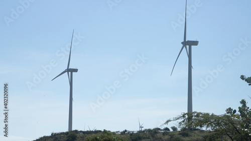 WIND GENERATORS IN A CLEAN ENERGY PARK ON TOP OF A HILL WITH THE SKY IN THE BACKGROUND