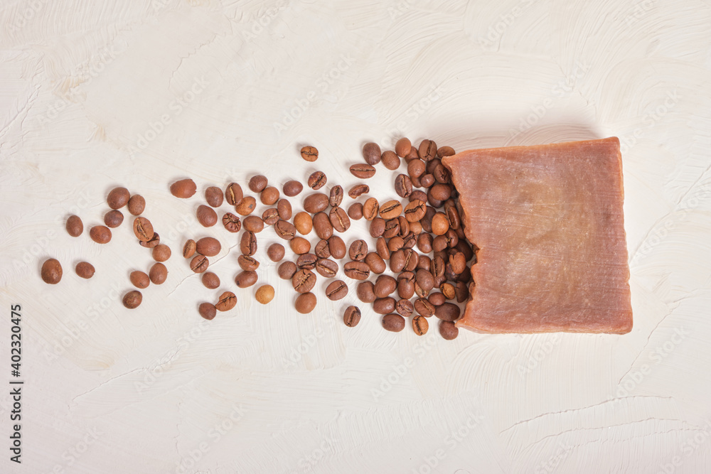 piece of cocoa homemade soap and coffee beans, beige background piece of cocoa homemade soap and coffee beans, beige background