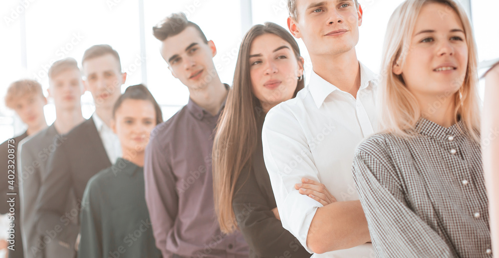 Fototapeta premium group of serious young people standing in a long queue