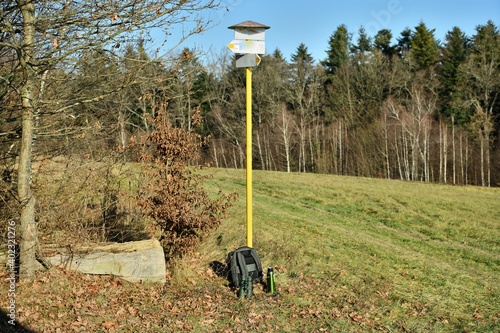 Yellow tourist sign with tourist aids such as a thermos, binoculars and a backpack
