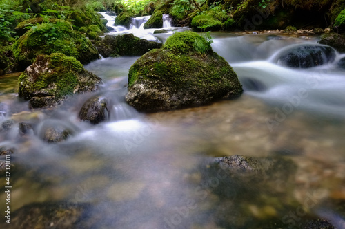 wonderful soft flowing brook with many rocks in the nature