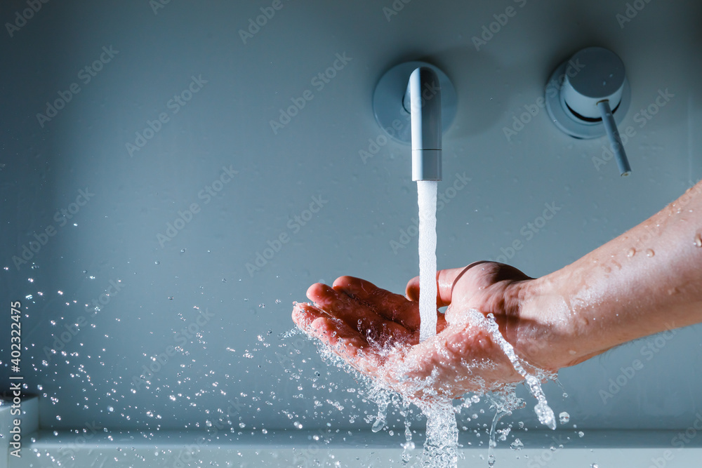 Fototapeta premium hand under the faucet with flowing water splash