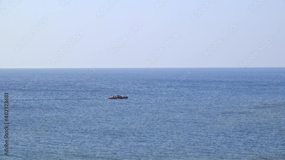 Refugees in rubber boat float in the middle of the ocean. Refugees in rubber boat float in the middle of the ocean.