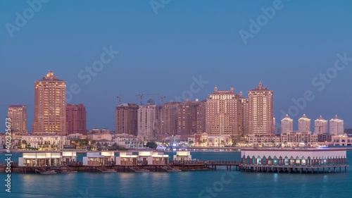 View from Katara Beach day to night transition timelapse after sunset in Doha, Qatar, towards the Pearl. Residential buildings skyline photo