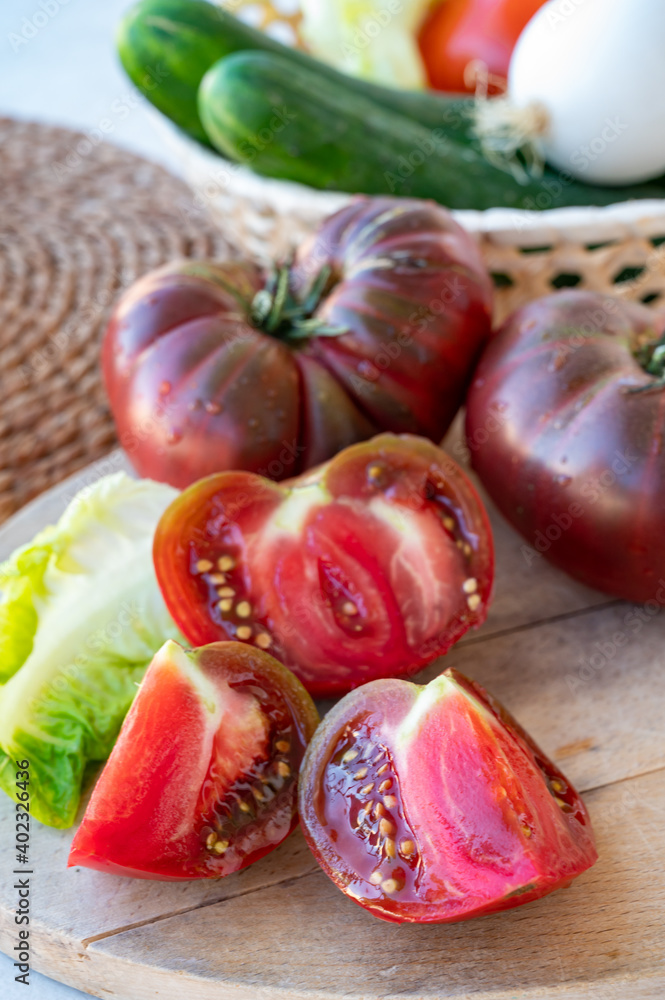 Making green salad with big ripe raddish-purple heirloom tomatoes Black Crimea Making green salad with big ripe raddish-purple heirloom tomatoes Black Crimea