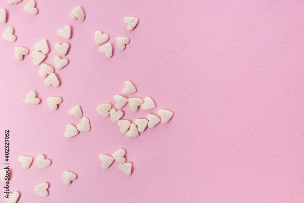Sugar heart shaped sprinkles on pink background