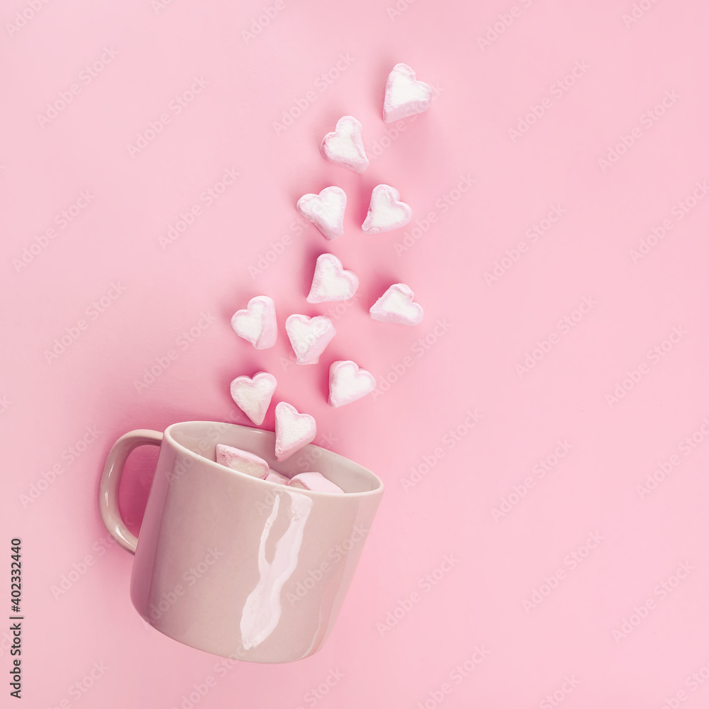 Marshmallows in the shape of hearts flying out of pink cup. Marshmallows in the shape of hearts flying out of pink cup.