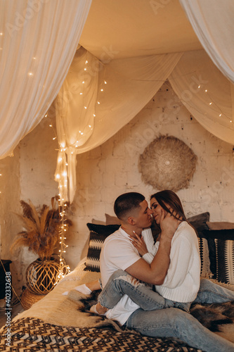 The guy and the girl celebrate the New Year. A loving couple have fun on Christmas in a cozy studio setting. New Year's love story. © dimadasha