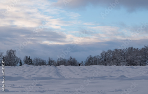 Winter day in the countryside. .Footprints in the snow. Snow covered hill. © Ieva