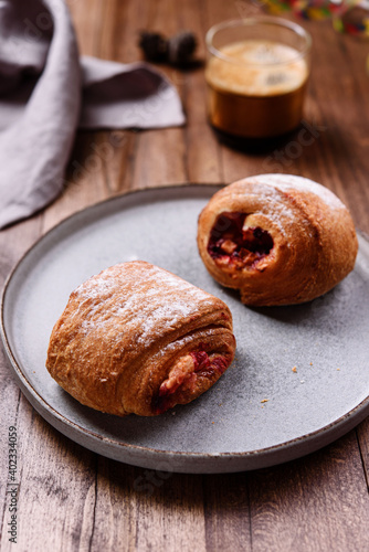 Puff pastry rolls with fruit and coffee on wooden table. Danish pastries. Christmas breakfast