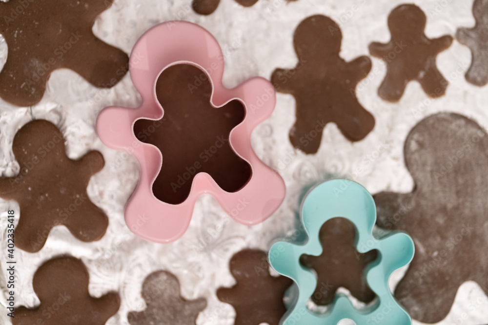 Fototapeta premium Boy teenager prepares for Christmas and bakes gingerbread men. Good New Year spirit. Delicious cookies.