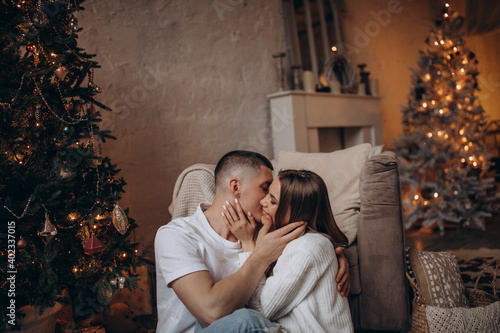 The guy and the girl celebrate the New Year. A loving couple have fun on Christmas in a cozy studio setting. New Year's love story.