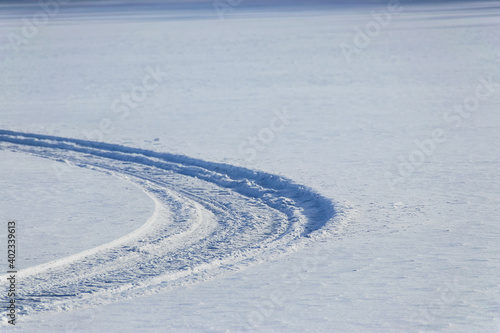 Obraz na płótnie snowmobile tracks on a frozen lake in finland