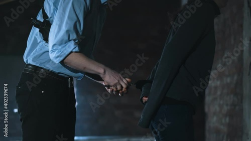 Police officer arresting young woman for drug possession