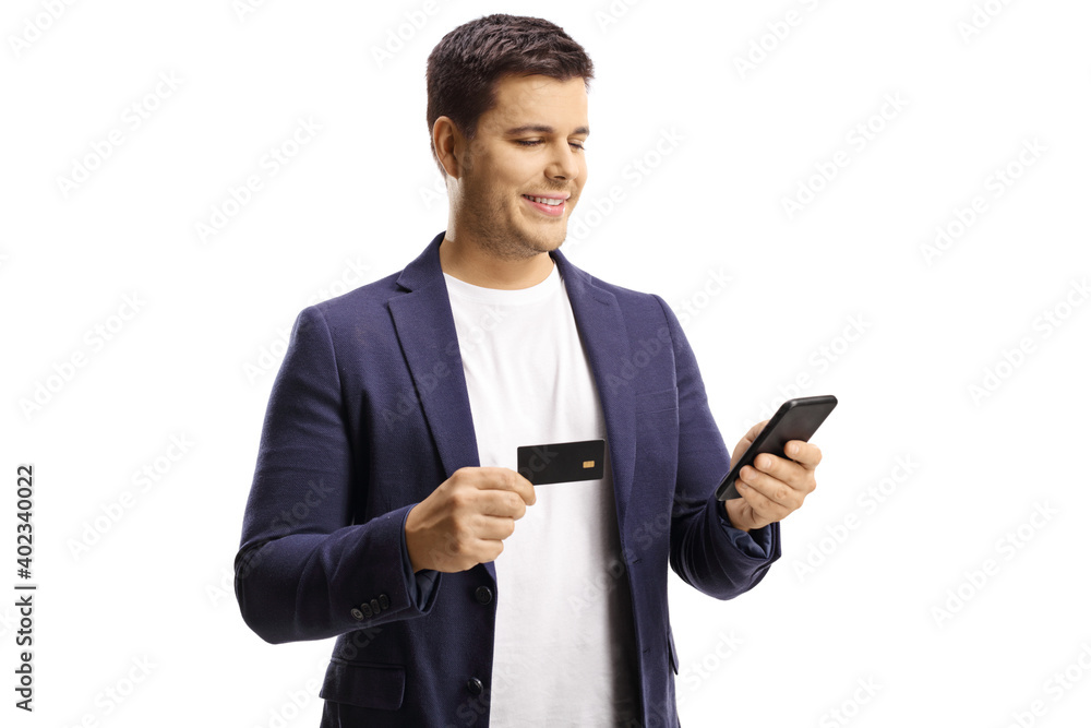 Young man holding a credit card and using a mobile phone Young man holding a credit card and using a mobile phone