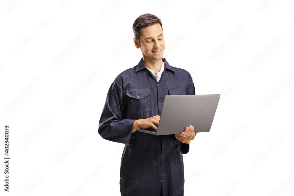 Young male worker in an overall uniform with a laptop computer