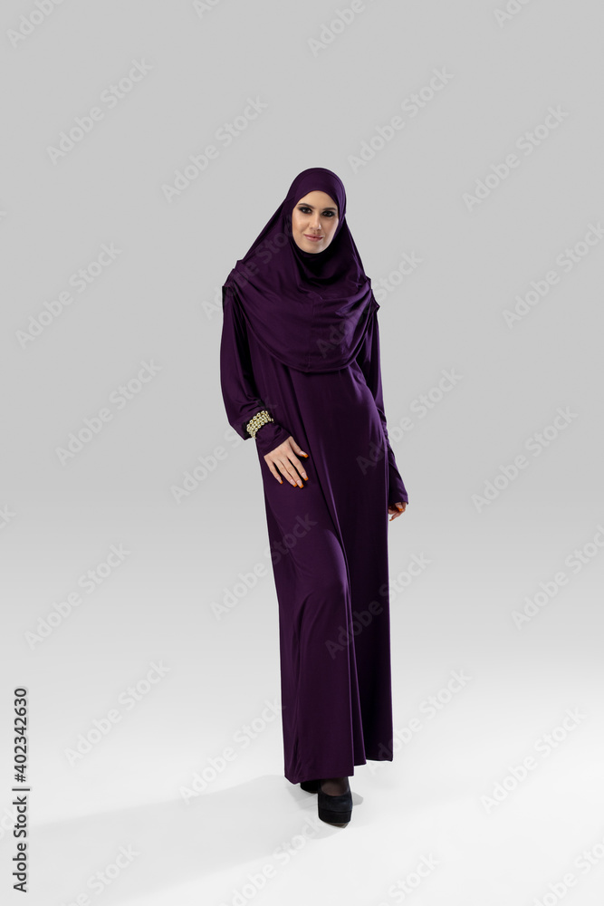 Queen. Beautiful arab woman posing in stylish hijab isolated on studio background with copyspace for ad. Fashion, beauty, style concept. Female model with trendy make up, manicure and accessories. Queen. Beautiful arab woman posing in stylish hijab isolated on studio background with copyspace for ad. Fashion, beauty, style concept. Female model with trendy make up, manicure and accessories.