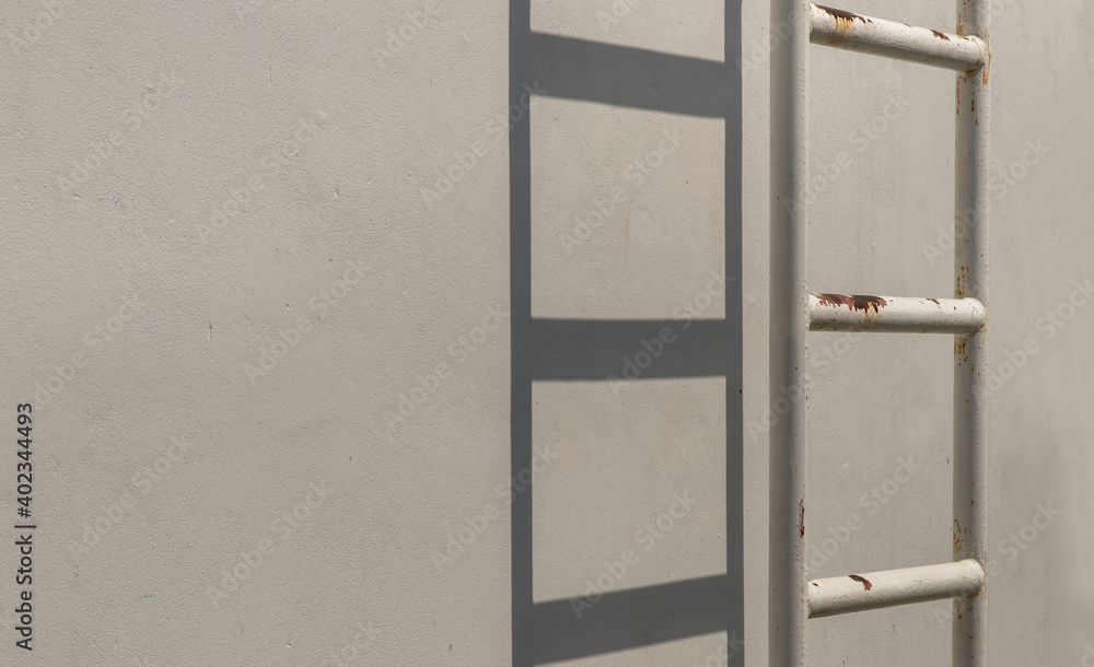 White metal fire escape attached to a wall and leading to the roof of a building. Copy space, No focus, specifically White metal fire escape attached to a wall and leading to the roof of a building. Copy space, No focus, specifically