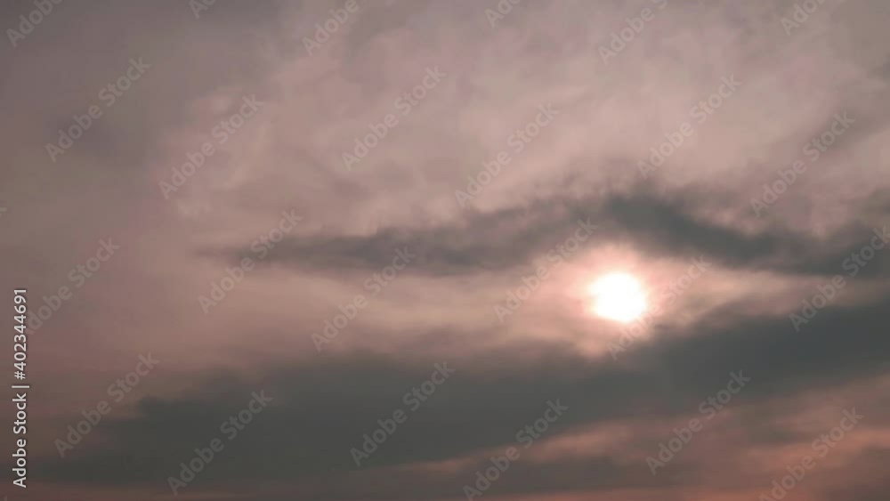 Eye of God shape of Building motion pastel pink n golden yellow cloud or dark scary gray cloudscape on sunrise sky background with bright sun light ray n sunbeam flare, 4k cinemagraph b-roll TimeLapse