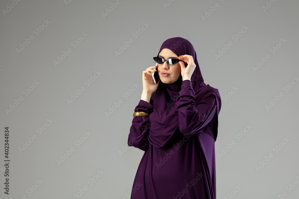 Business. Beautiful arab woman posing in stylish hijab isolated on studio background with copyspace for ad. Fashion, beauty, style concept. Female model with trendy make up, manicure and accessories. Business. Beautiful arab woman posing in stylish hijab isolated on studio background with copyspace for ad. Fashion, beauty, style concept. Female model with trendy make up, manicure and accessories.