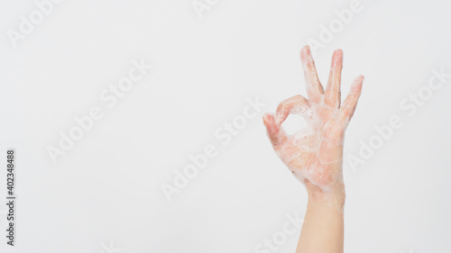 Hand is do a okay hand sign and have foam soap bubbles on a white isolated background