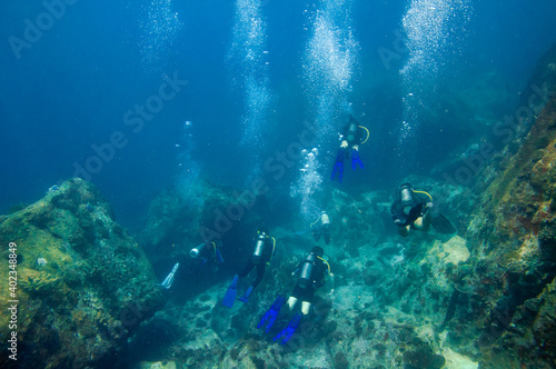 Group of divers over the ocean floor reef boulders © MF1688