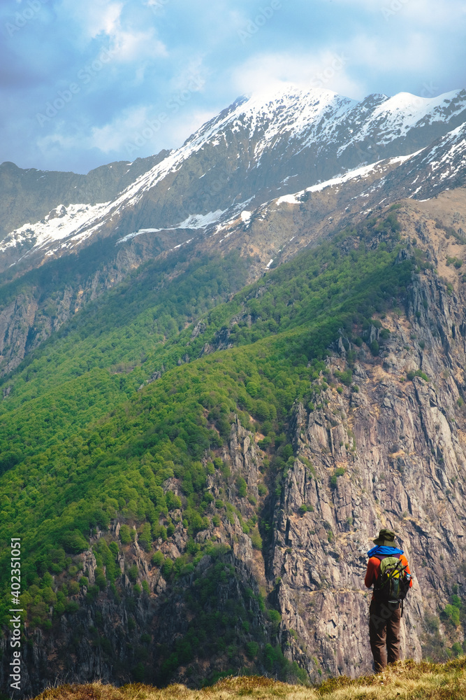 A man hiker with backpack, look at the stuuning mountain landscape from a panoramic point in the wild  Val Grande National Park,  Europe, Piedmont Italy.