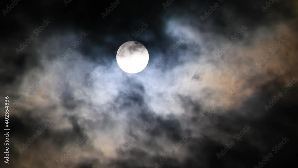 The full moon rising among clouds The full moon rising among clouds