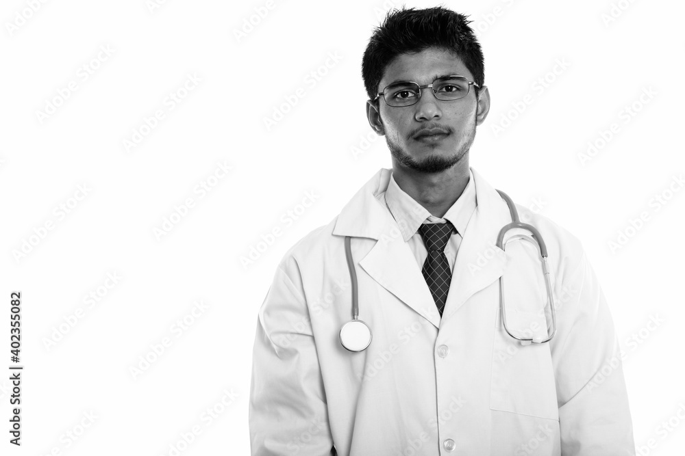 Studio shot of young handsome Indian man doctor Studio shot of young handsome Indian man doctor