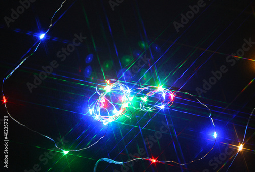 Multicolored illumination with star filter effect. Dark background. Led lights. Christmas. Party. Festive.