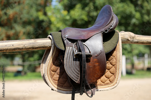 Old leather saddle with stirrups for show jumping race