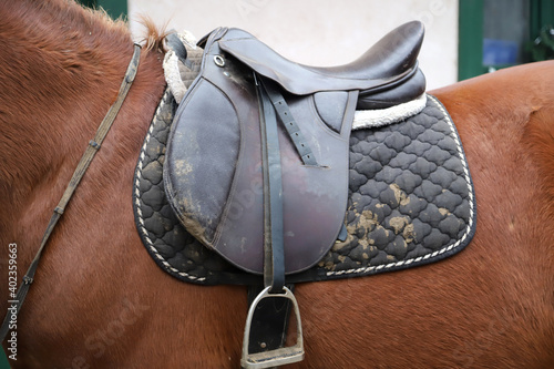 Old leather saddle with stirrups for show jumping race