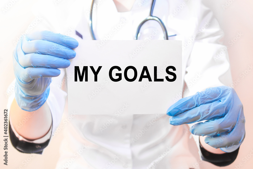 The doctor's blue - gloved hands show the word MY GOALS - . a gloved hand on a white background. Medical concept. the medicine The doctor's blue - gloved hands show the word MY GOALS - . a gloved hand on a white background. Medical concept. the medicine