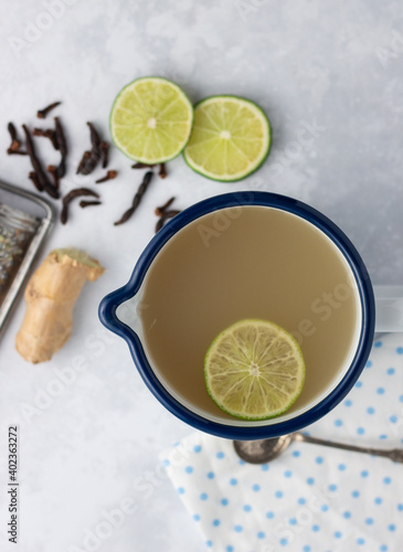 Ginger and lime herbal warming tea in enamel cup photo