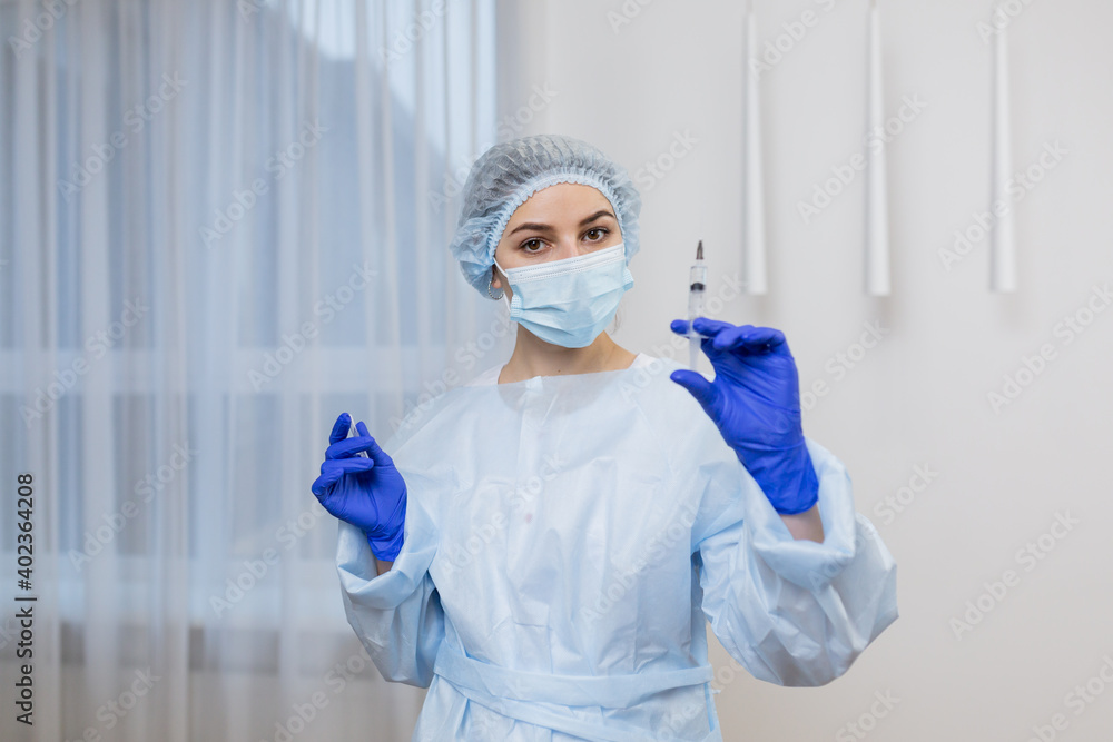 Young woman-doctor in medical uniform and gloves holds an injection in her hands. healthcare and medical concept - close up photo Young woman-doctor in medical uniform and gloves holds an injection in her hands. healthcare and medical concept - close up photo