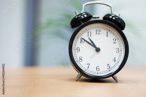 Desktop retro alarm clock on wooden table in office