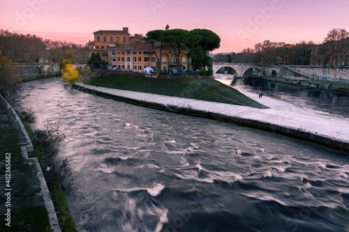 il tramonto sull'isola tiberina ed il fiume tevere, con stormi di uccelli nel cielo photo