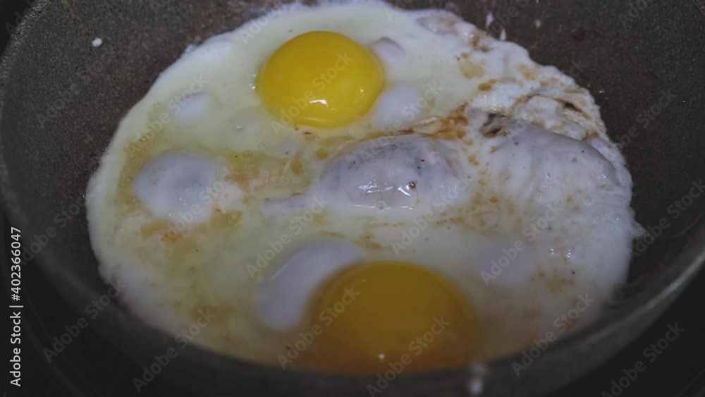 Cooking two fried eggs bubbling in a hot pan for breakfast Cooking two fried eggs bubbling in a hot pan for breakfast