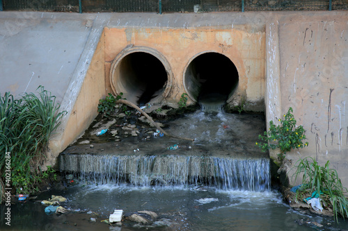 salvador, bahia, brazil - december 30, 2020: sewer pipe is spouting in a sewage channel on the Rio Camurugipe, in the city of Salvador. photo