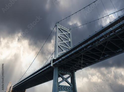 Fototapeta Naklejka Na Ścianę i Meble -  View of the historic Benjamin Franklin Bridge with storm sky in Philadelphia Pennsylvania.
