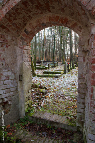 Old cemetery seen through an entrance of an old abandoned church