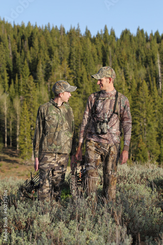 father and son hunting in camouflage together standing close full-length