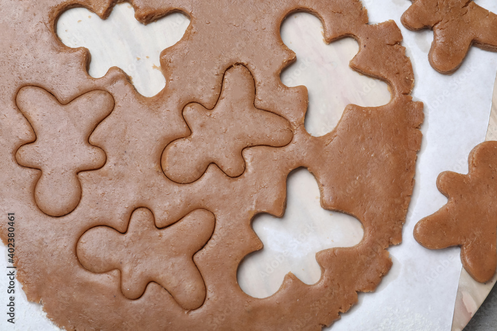 Making homemade Christmas cookies. Dough for gingerbread man on parchment, flat lay Making homemade Christmas cookies. Dough for gingerbread man on parchment, flat lay