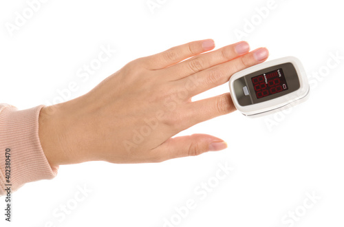 Woman using pulse oximeter for oxygen level testing on white background, closeup