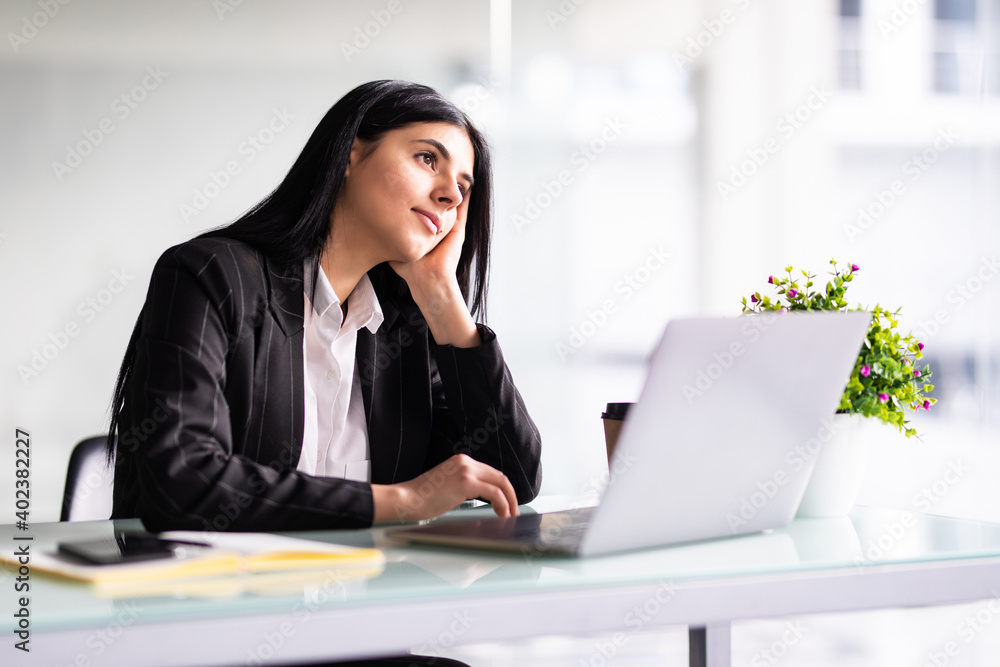 Portrait of tired young business woman with laptop at the office Portrait of tired young business woman with laptop at the office