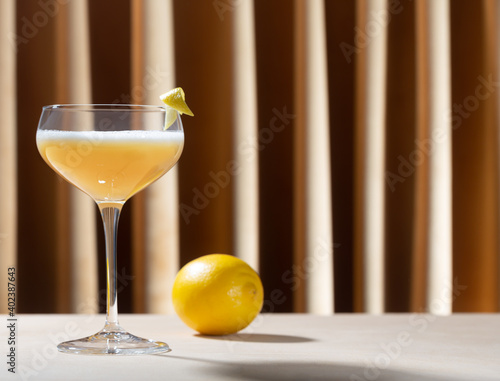 Obraz na plátně Glass filled with whiskey sour cocktail with lemon on the table