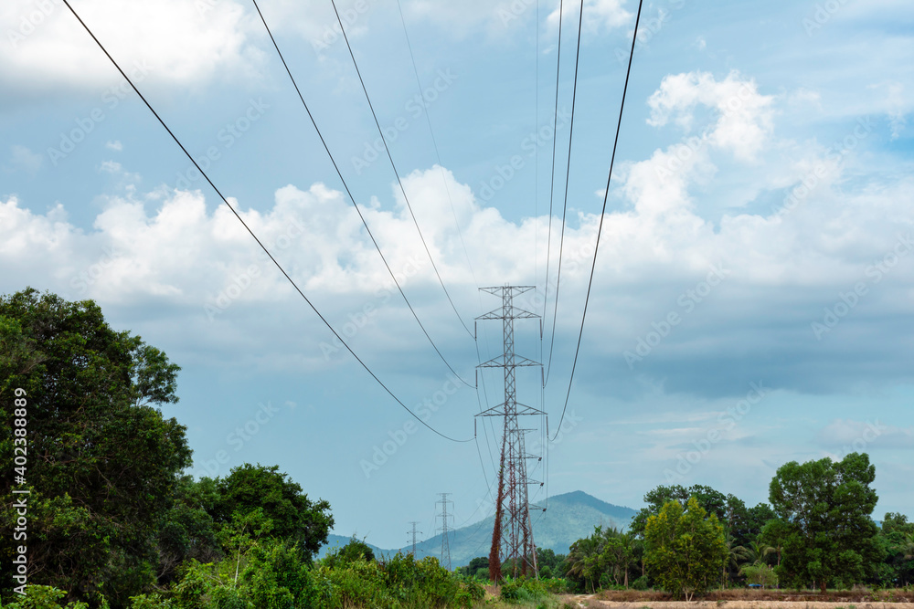 Electricity transmission line with green tree nature, Green conservative energy, Energy be friendly with environment concept, Power distribution pylon system to rural community and countryside Electricity transmission line with green tree nature, Green conservative energy, Energy be friendly with environment concept, Power distribution pylon system to rural community and countryside